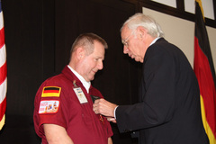 Ambassador Klaus Scharioth awards Tim Chopp the Order of Merit of the Federal Republic of Germany.